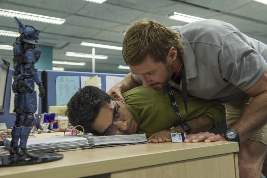 Filmstill aus Neill Blomkamps CHAPPIE; Vincent (Hugh Jackman) setzt Deon (Dev Patel) unter Druck, Copyright Sony Pictures