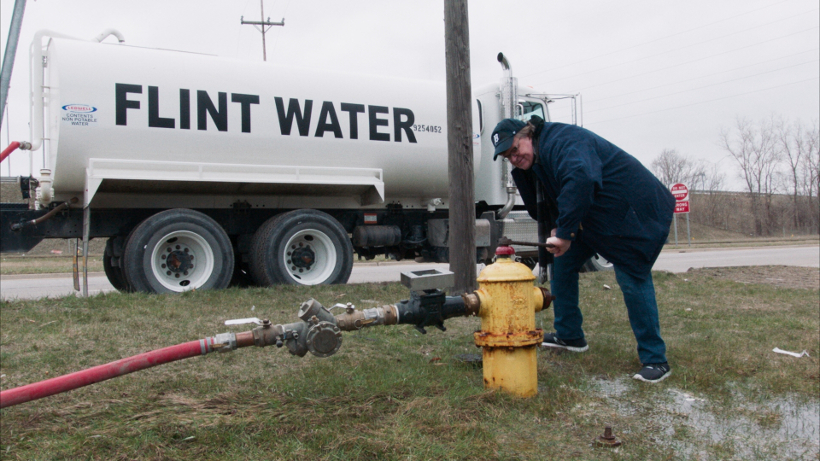 Szenenbild aus FAHRENHEIT 11/9 (2018) - Moore zapft vergiftetes Wasser aus dem Flint River. - © Weltkino