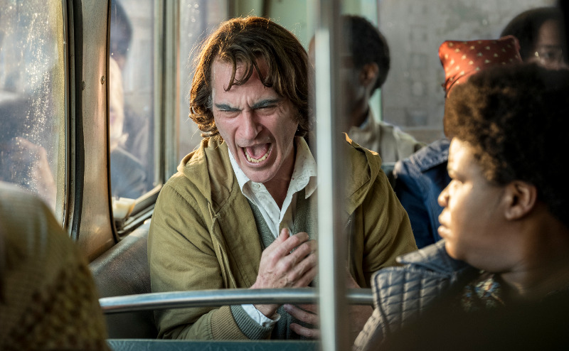 Szenenbild aus JOKER (2019) - Arthur (Joaquin Phoenix) leidet an unkontrollierten Lachanfällen. - © Warner Bros.