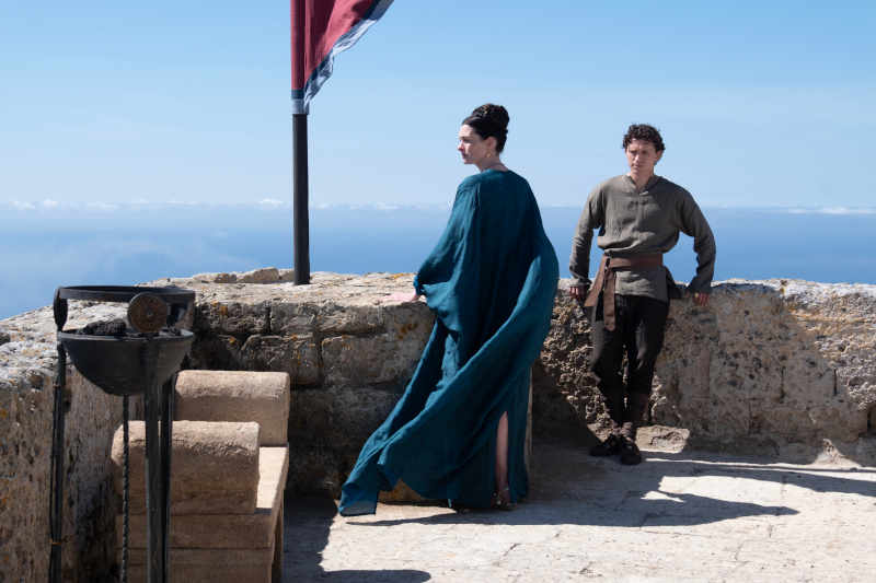 Szenenbild aus THE ODYSSEY - Penelope (Anne Hathaway) und ihr Sohn Telemachos (Tom Holland) - Szenenbild aus THE ODYSSEY - Odysseus (Matt Damon) und Athena (Zendaya) - © Universal Studios. All Rights Reserved.